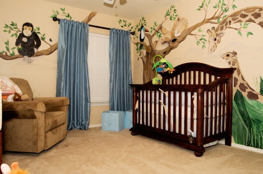 jungle-theme-for-baby-boy-room-with-wall-decals-of-tree-and-animals-and-blue-curtain-for-the-windows-also-brown-color-for-the-cradle-and-the-couch-945x627