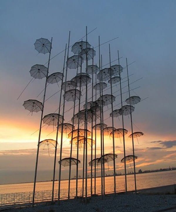 instalasi payung ini berdiri pada tiang-tiang seperti tiang bambu. Ada di dekat hotel Macedonia Palace, Yunani