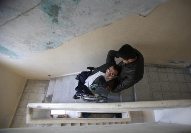 Ahmed al-Sawaferi dibantu keponakannya menuruni tangga