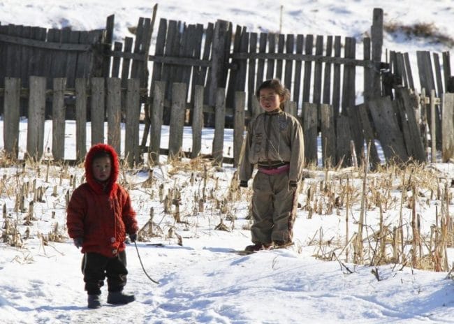 Dua orang anak berdiri di atas salju