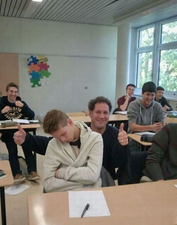 Guru berpose dengan muridnya yang tertidur di kelas